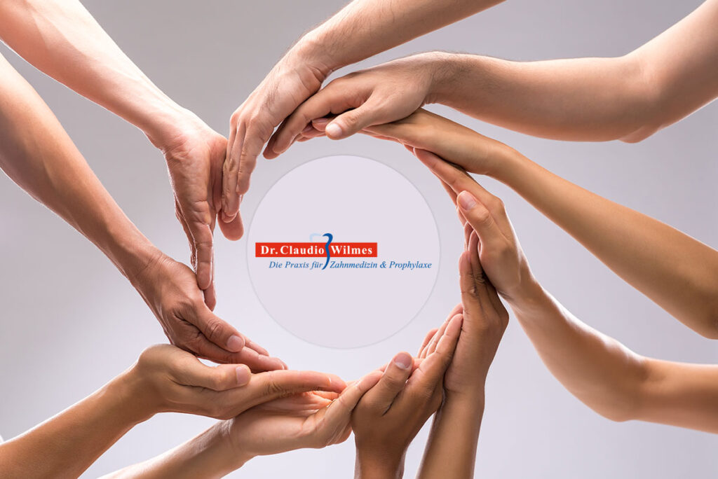 Mehrere Hände formen gemeinsam einen Kreis um ein Logo mit der Aufschrift ‚Gemeinsam für Ihre Zahngesundheit‘ – Symbol für Teamarbeit und Patientenorientierung.